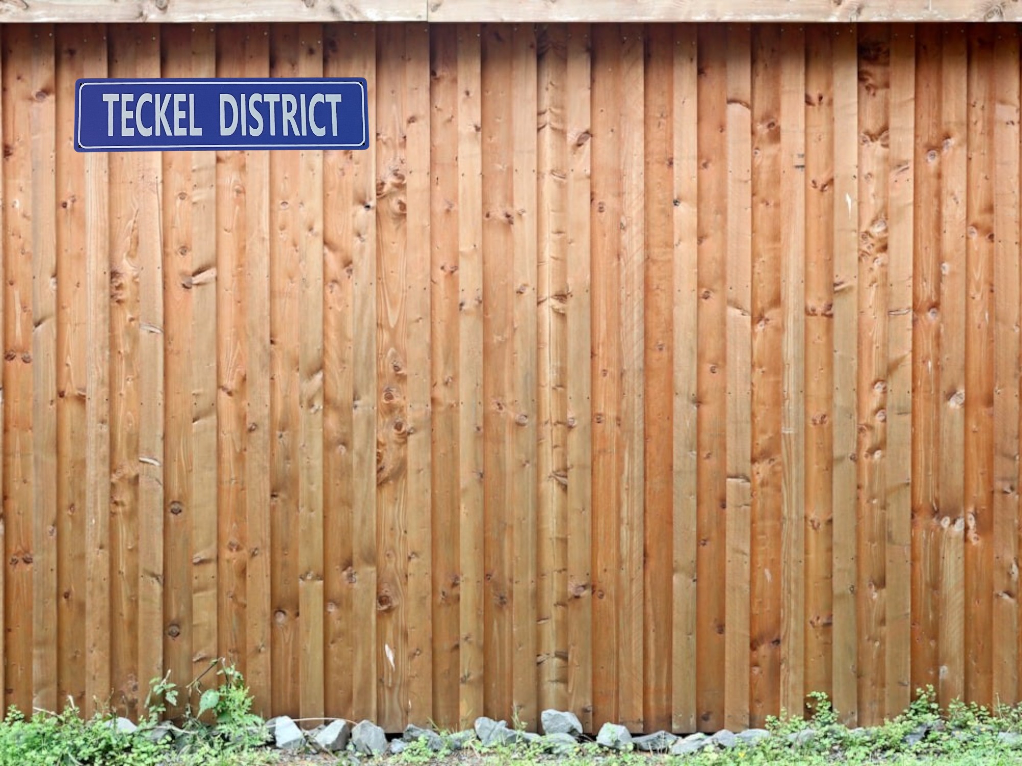 Teckel district straatnaam bord blauw op schutting jpg